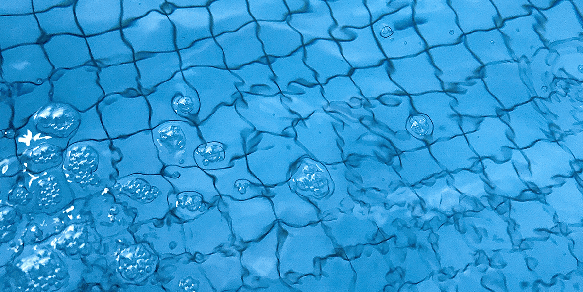 Vivid blue pool water with black grout tile floor